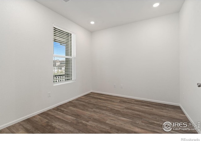 unfurnished room with recessed lighting, wood finished floors, and baseboards