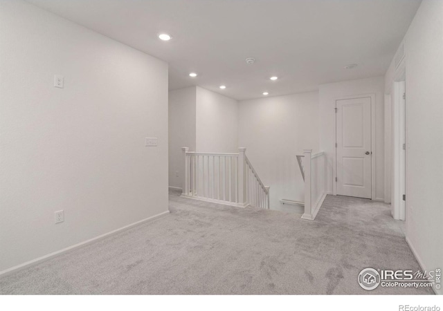 carpeted spare room featuring baseboards and recessed lighting