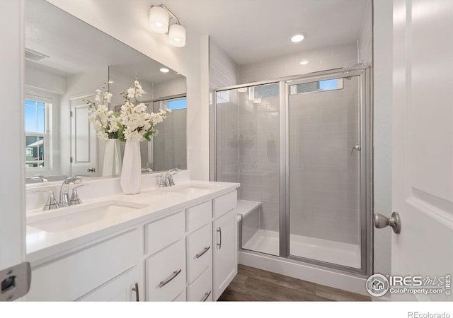 bathroom with hardwood / wood-style floors, vanity, and walk in shower