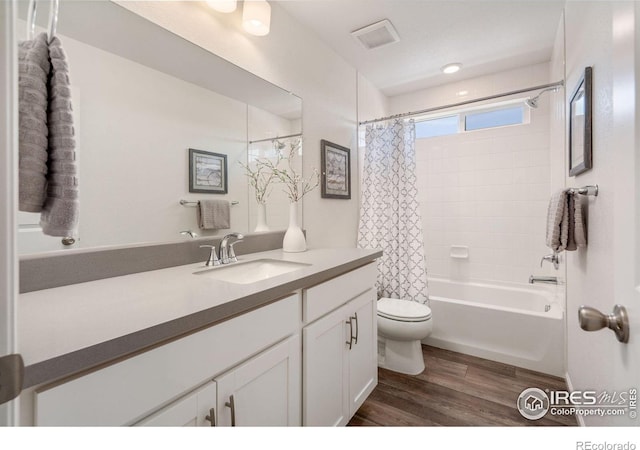 full bathroom featuring vanity, hardwood / wood-style floors, shower / bathtub combination with curtain, and toilet