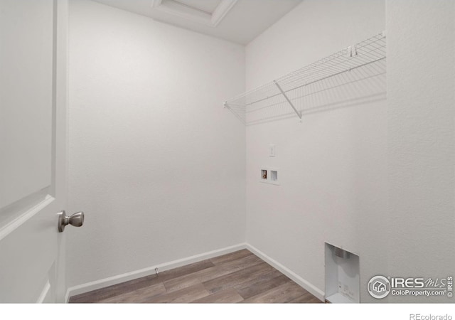 washroom featuring hookup for a washing machine, attic access, light wood-type flooring, laundry area, and baseboards