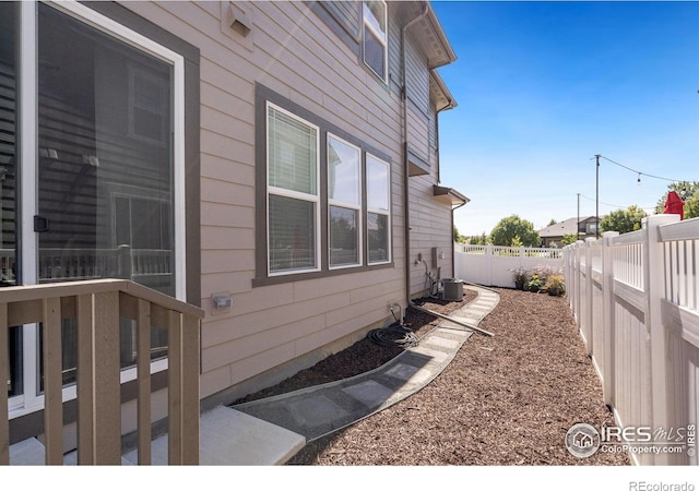 view of side of property with cooling unit and a fenced backyard