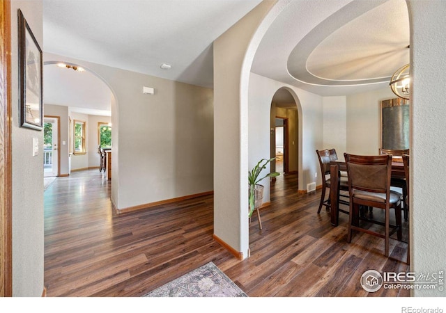 corridor featuring dark hardwood / wood-style flooring and a notable chandelier