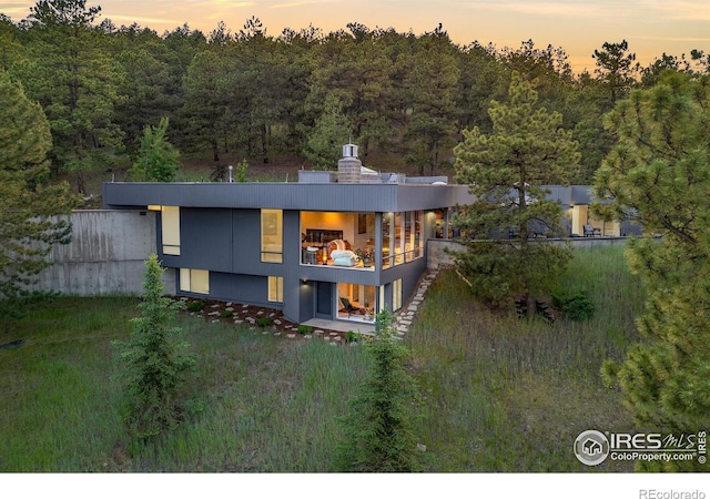 271 Anemone Dr, Boulder, CO 80302 - rear view of property featuring a balcony, a wooded view, and a chimney