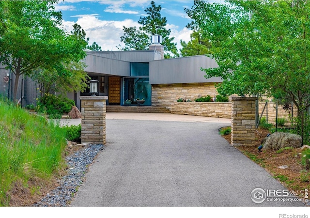 271 Anemone Dr, Boulder, CO 80302 - modern home with a chimney, driveway, and stone siding