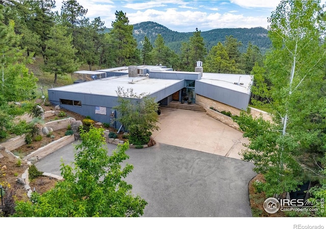 271 Anemone Dr, Boulder, CO 80302 - mid-century home with a view of trees, a mountain view, and a chimney