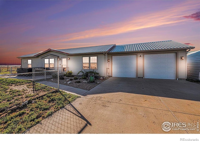 view of front of house featuring a garage, fence, metal roof, and concrete driveway