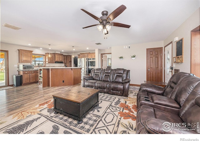 living room featuring light wood finished floors, recessed lighting, visible vents, ceiling fan, and baseboards