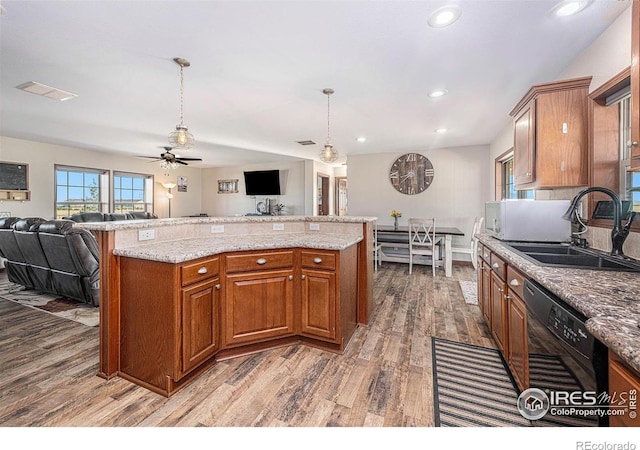 kitchen featuring a sink, visible vents, open floor plan, and dishwasher