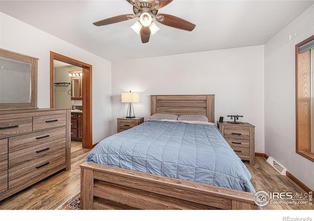 bedroom with baseboards, visible vents, connected bathroom, ceiling fan, and wood finished floors