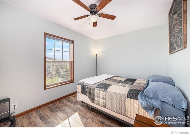 bedroom with a ceiling fan, baseboards, and wood finished floors