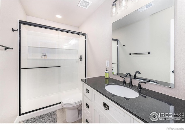 full bath with visible vents, a shower stall, toilet, and vanity