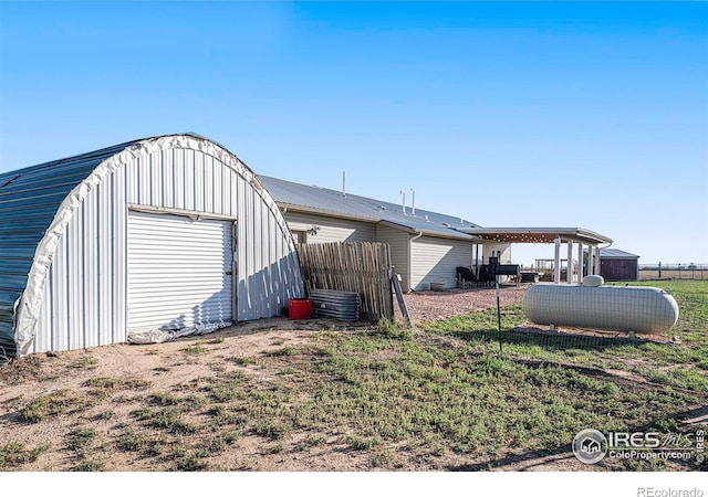 exterior space featuring an outbuilding, fence, and a garage