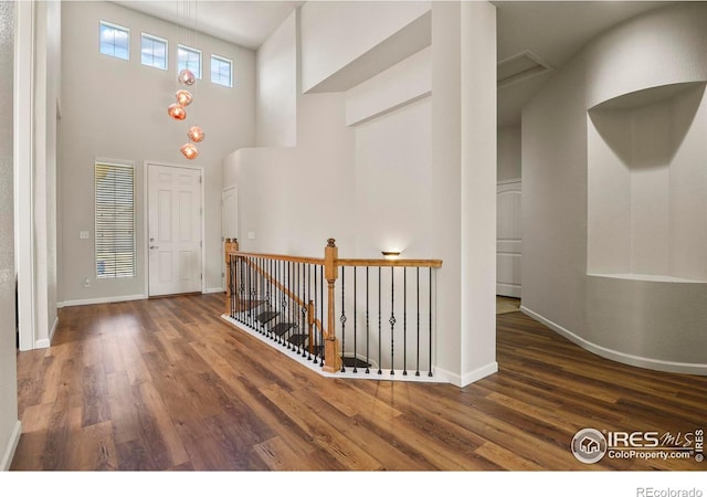 entryway with a towering ceiling and dark hardwood / wood-style flooring