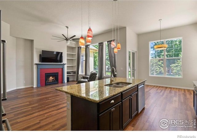 kitchen with a fireplace, pendant lighting, sink, ceiling fan, and dark wood-type flooring