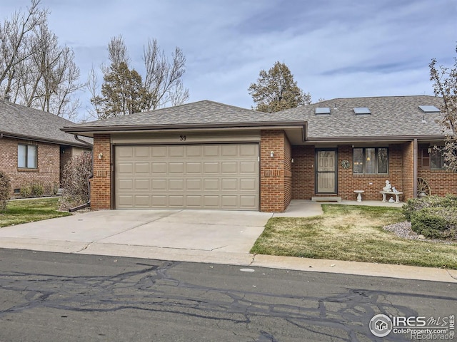 single story home with a front lawn, driveway, a shingled roof, a garage, and brick siding