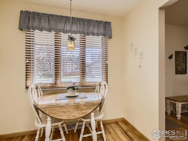 dining space with baseboards and light wood finished floors