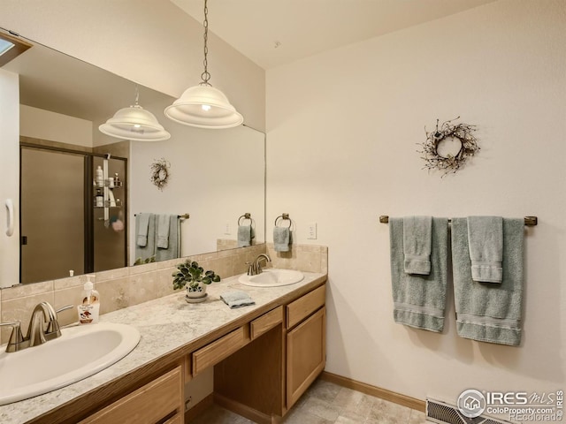 full bath featuring a shower stall, double vanity, baseboards, and a sink