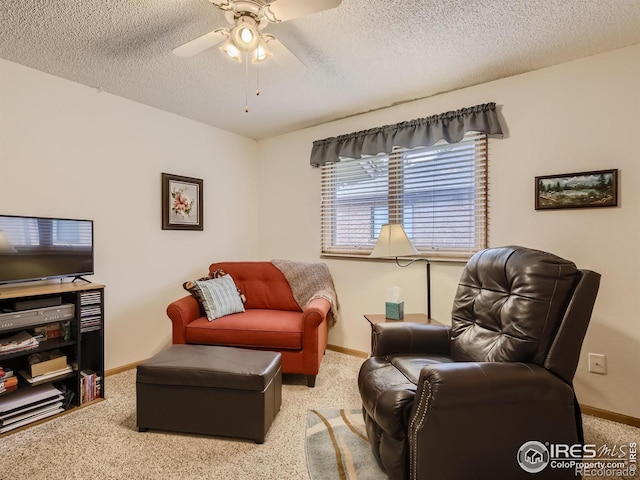 living area featuring baseboards, a textured ceiling, a ceiling fan, and carpet