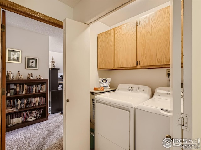 clothes washing area featuring a textured ceiling, cabinet space, carpet floors, and washer and clothes dryer