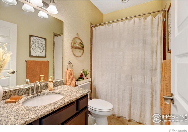 bathroom featuring tile patterned floors, a shower with curtain, toilet, and vanity