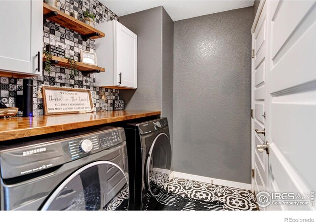 laundry area featuring separate washer and dryer and cabinets