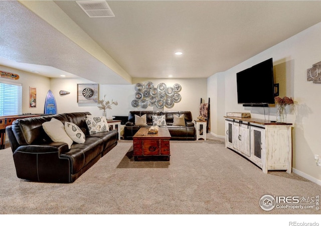 carpeted living room featuring a textured ceiling