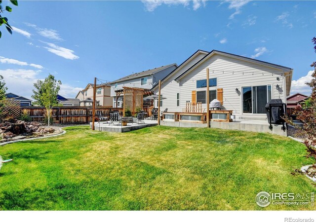 rear view of property with a yard and a patio area