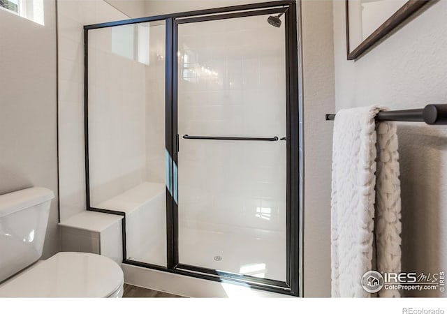 bathroom featuring toilet and walk in shower