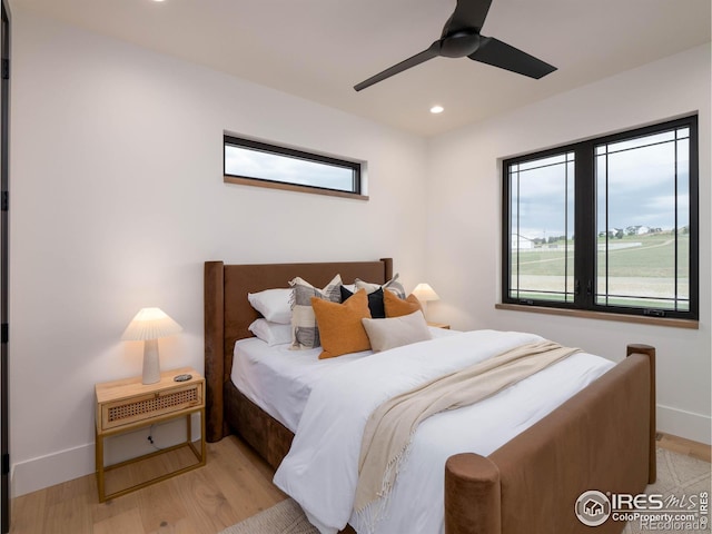 bedroom with light hardwood / wood-style flooring, multiple windows, and ceiling fan