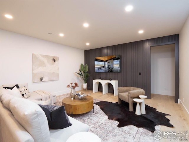 living room featuring light hardwood / wood-style flooring and wooden walls