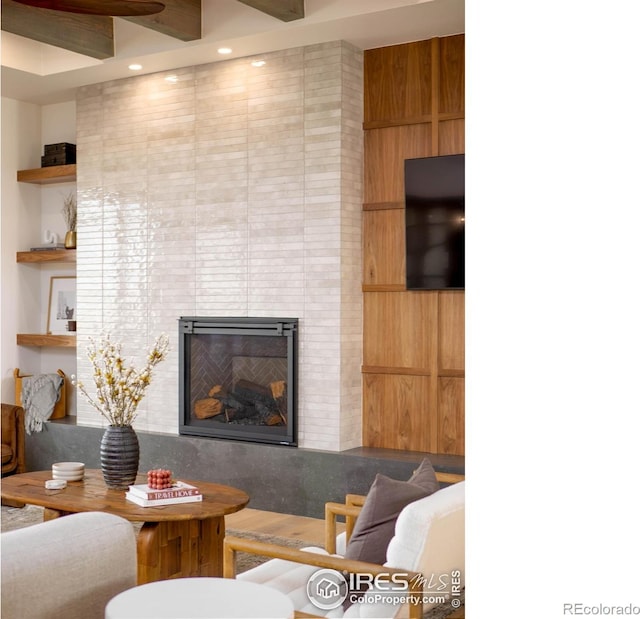 living room with beam ceiling and built in shelves