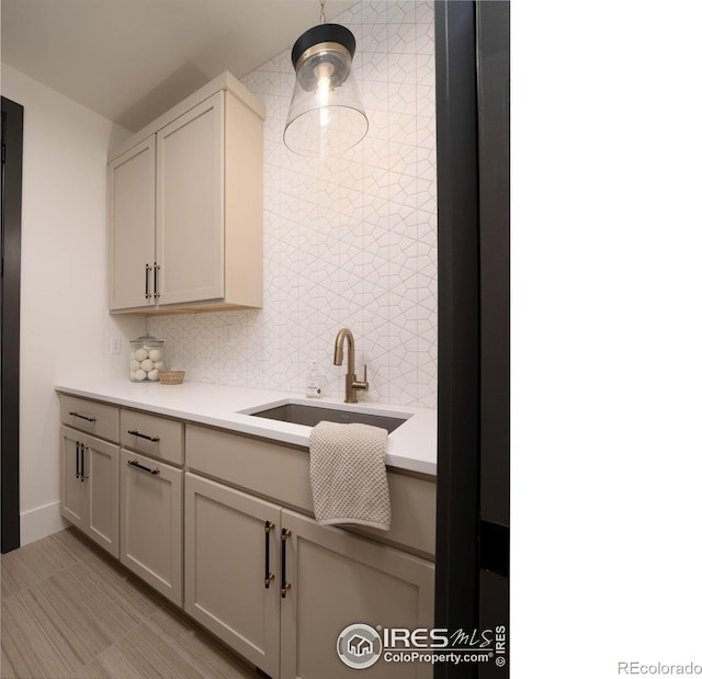 kitchen featuring backsplash, sink, and decorative light fixtures