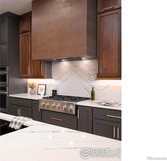 kitchen with dark brown cabinetry, wall chimney exhaust hood, stainless steel gas stovetop, and tasteful backsplash