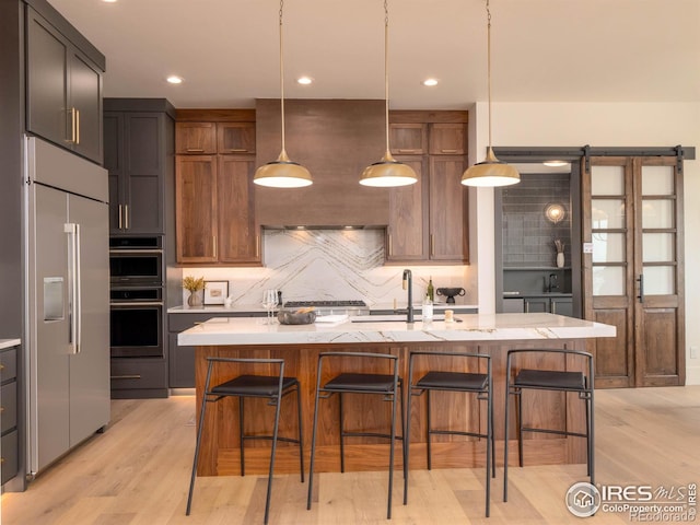 2550 Branding Iron Dr, Severance, CO 80524 - kitchen with built in fridge, backsplash, light wood-type flooring, a kitchen breakfast bar, and recessed lighting