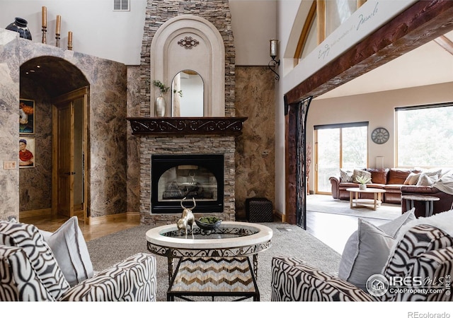 living room featuring a fireplace, lofted ceiling with beams, and hardwood / wood-style flooring