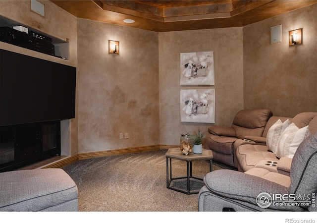 living room featuring a tray ceiling and carpet