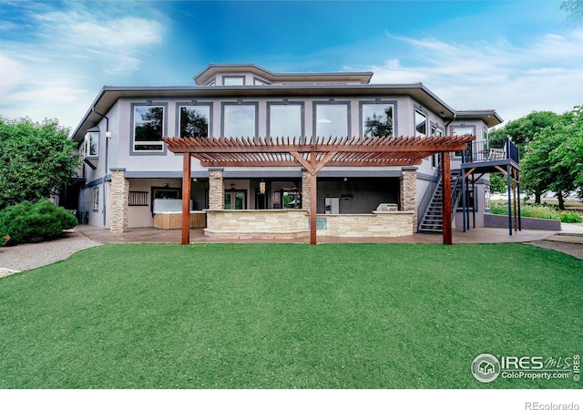 back of property featuring a pergola, a patio area, a lawn, and exterior kitchen