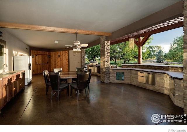 dining area featuring ceiling fan, beam ceiling, and sink