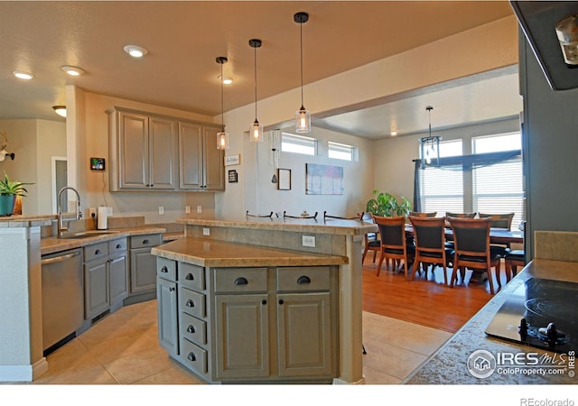 kitchen with a center island, sink, hanging light fixtures, light tile patterned floors, and stainless steel dishwasher