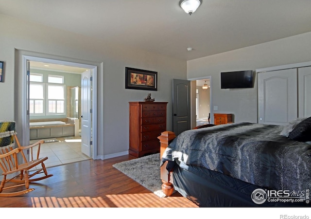 bedroom with light hardwood / wood-style floors and ensuite bathroom