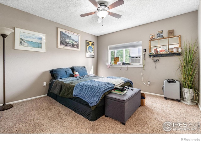 bedroom with ceiling fan, carpet floors, and a textured ceiling