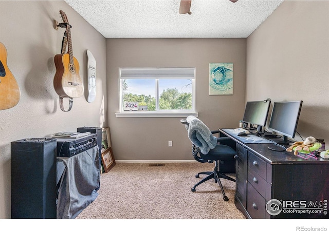 office space featuring a textured ceiling, ceiling fan, and light colored carpet