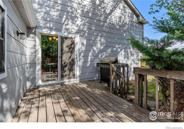 wooden deck featuring a grill