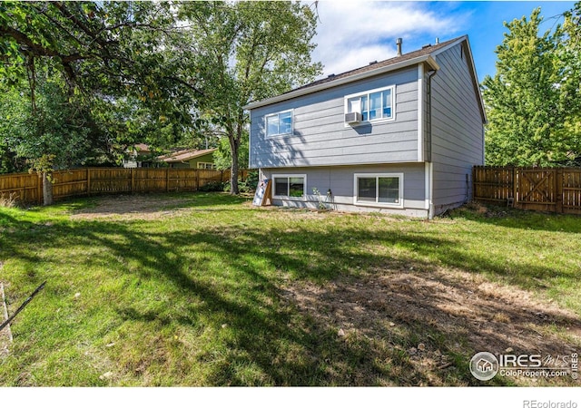 rear view of property featuring a yard and cooling unit