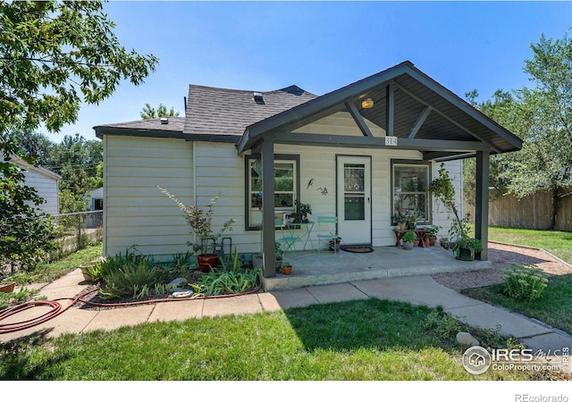 bungalow with a porch and a front lawn