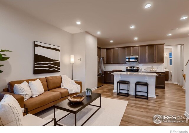 living room with sink and light wood-type flooring