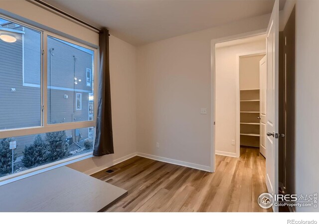 interior space with a walk in closet, light hardwood / wood-style floors, and a closet