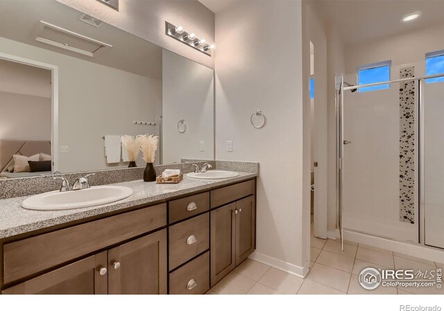 bathroom featuring tile patterned flooring, an enclosed shower, and vanity