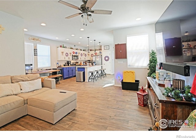 living room featuring light hardwood / wood-style flooring and ceiling fan